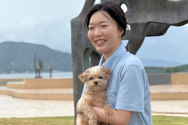 公園で犬を抱いたペットシッターの女性